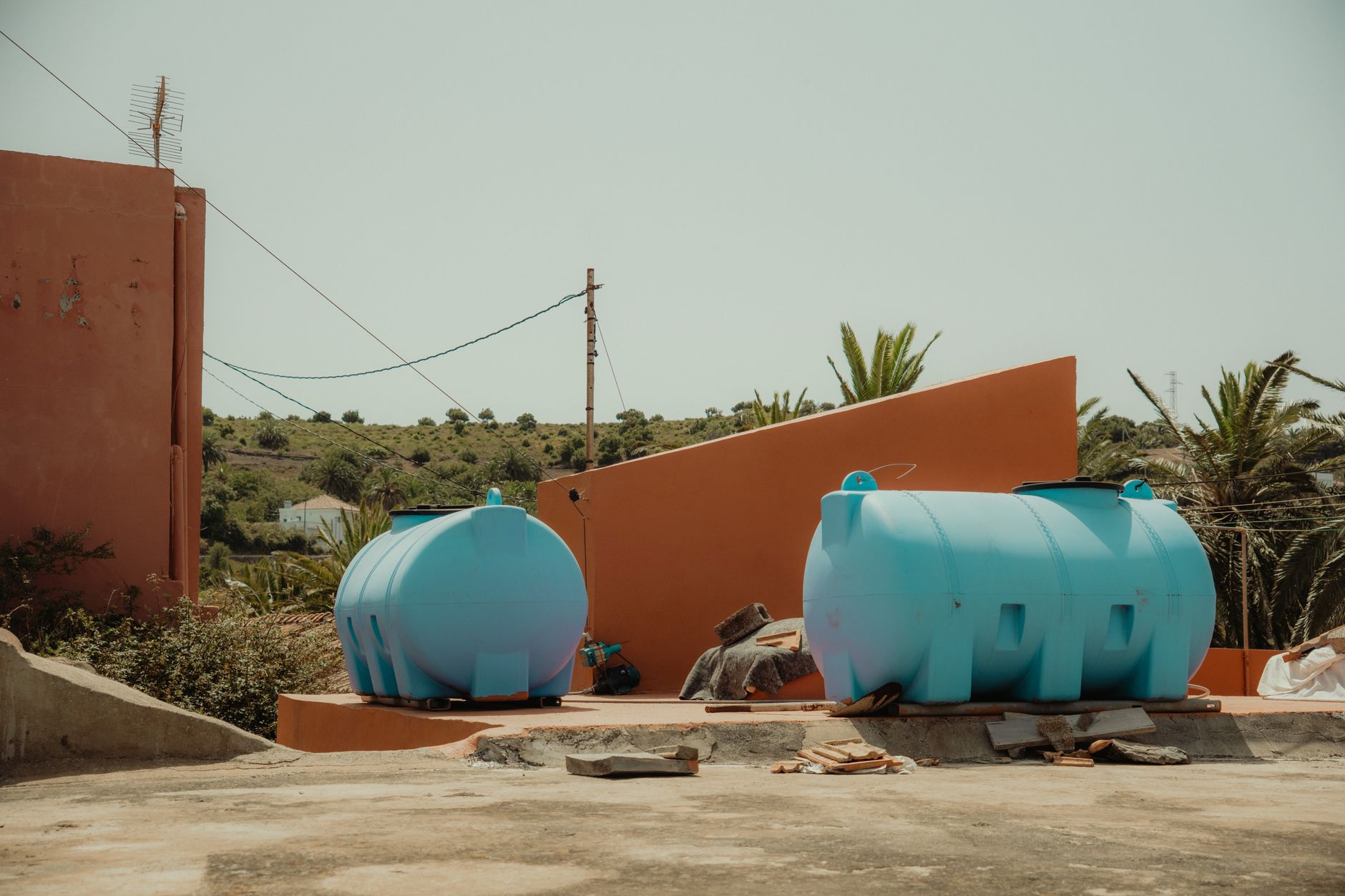Large green polyethylene above ground water storage tank installed in a rural backyard