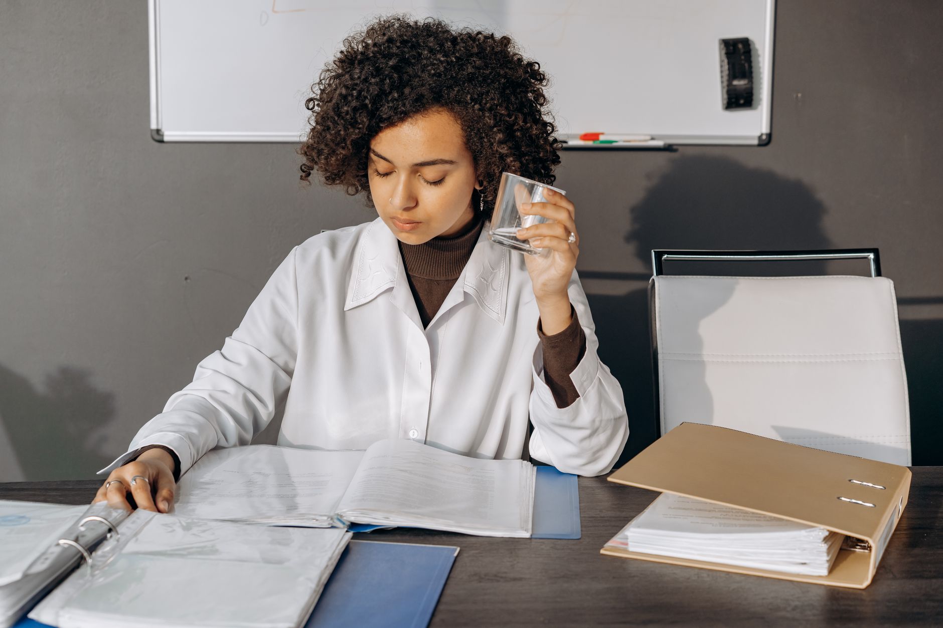 Person reading a printed municipality water quality report at a kitchen table.