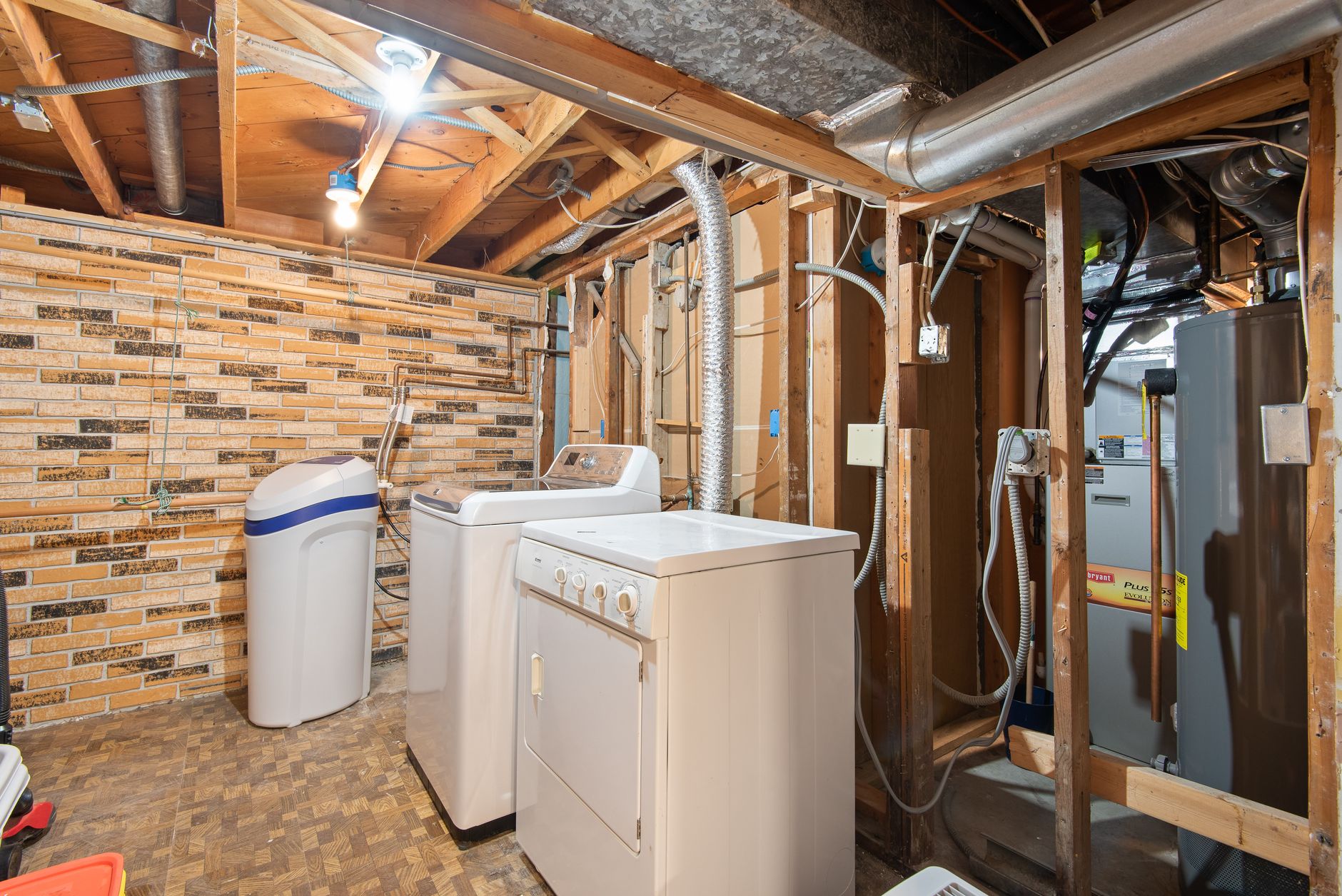 Close-up of a traditional salt-based water softener tank in a basement.