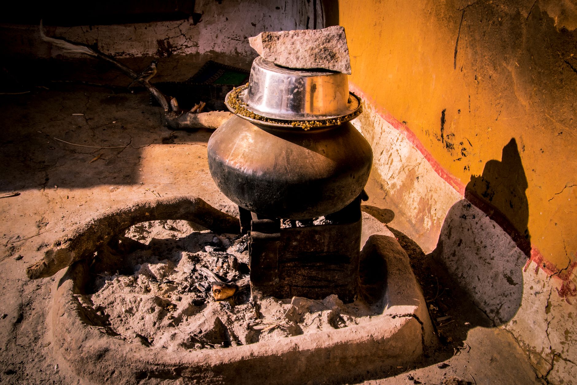 Cast iron wood cookstove with a steaming kettle in a rustic kitchen